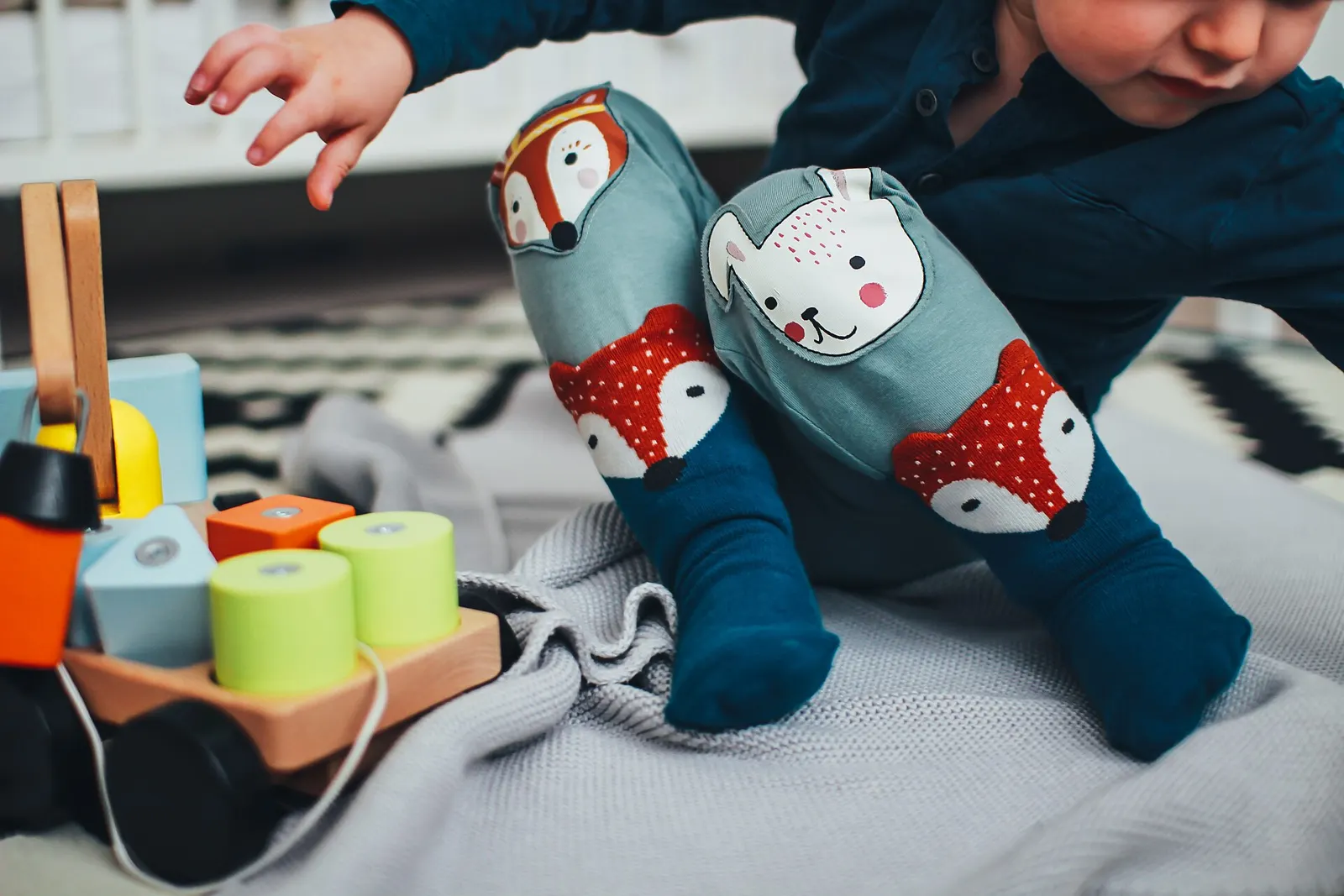 طفل صغير يلعب بألعاب خشبية